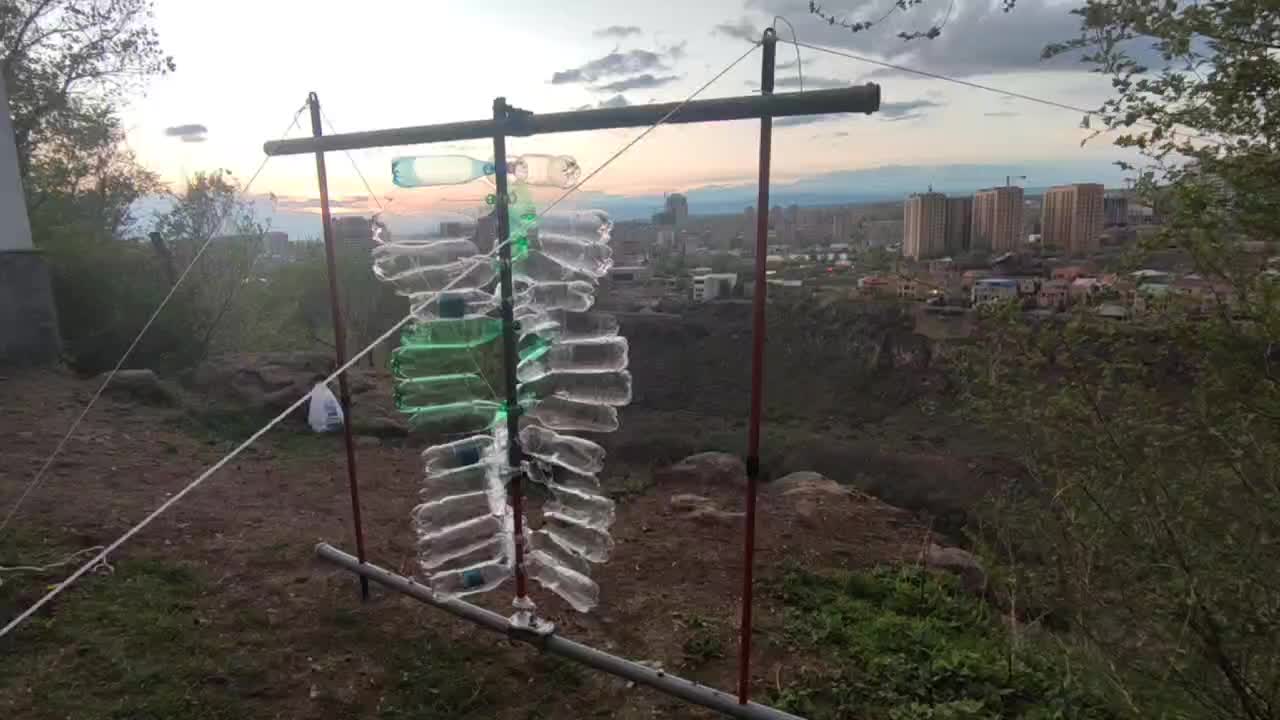 A BareWind prototype turbine built from recycled plastic bottles, spinning at sunset above Yerevan